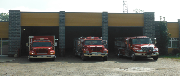 Fire station located in Brownsville, building and 3 fire engines inside of a building